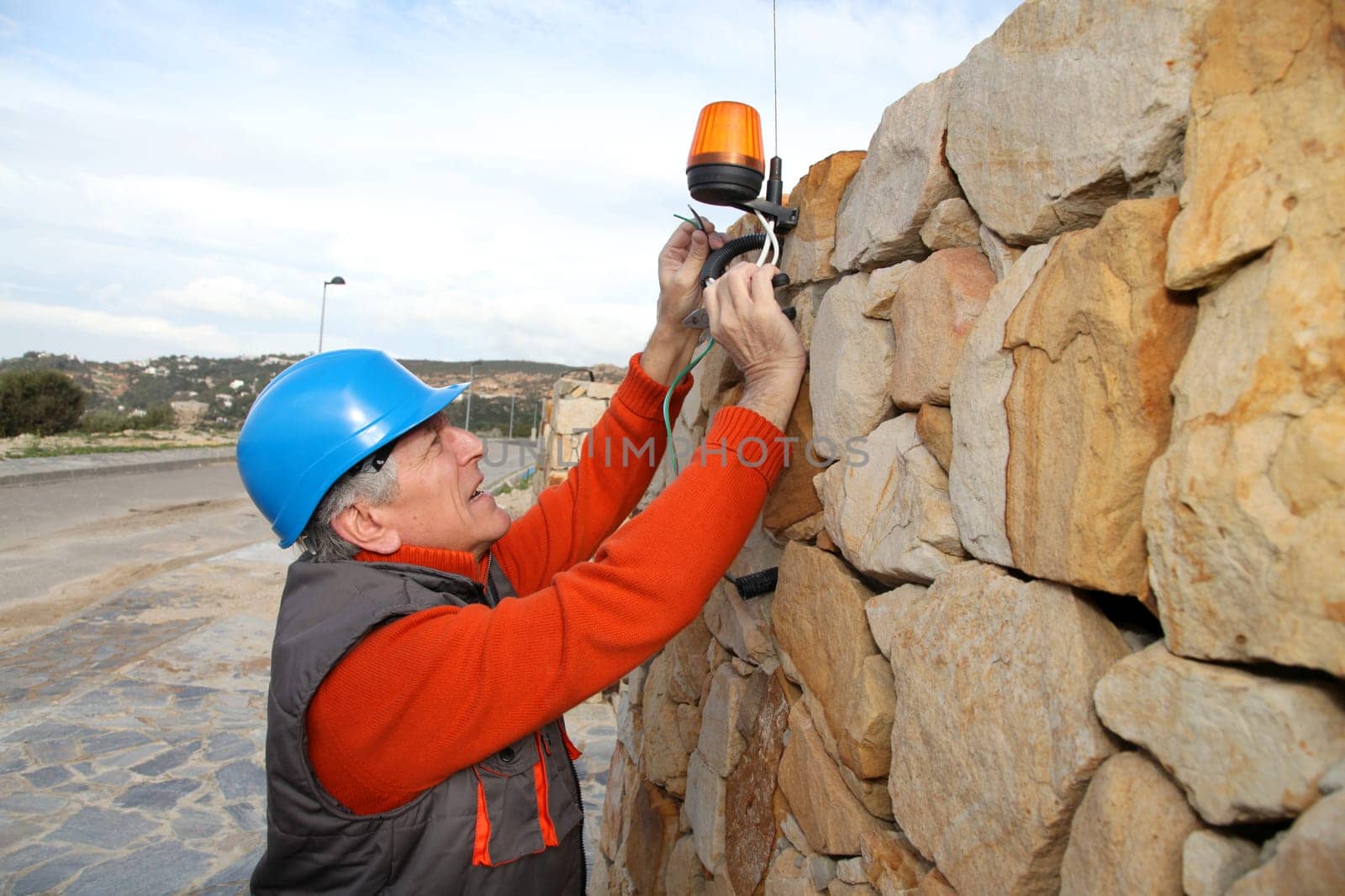 Worker with security helmet installing gate system