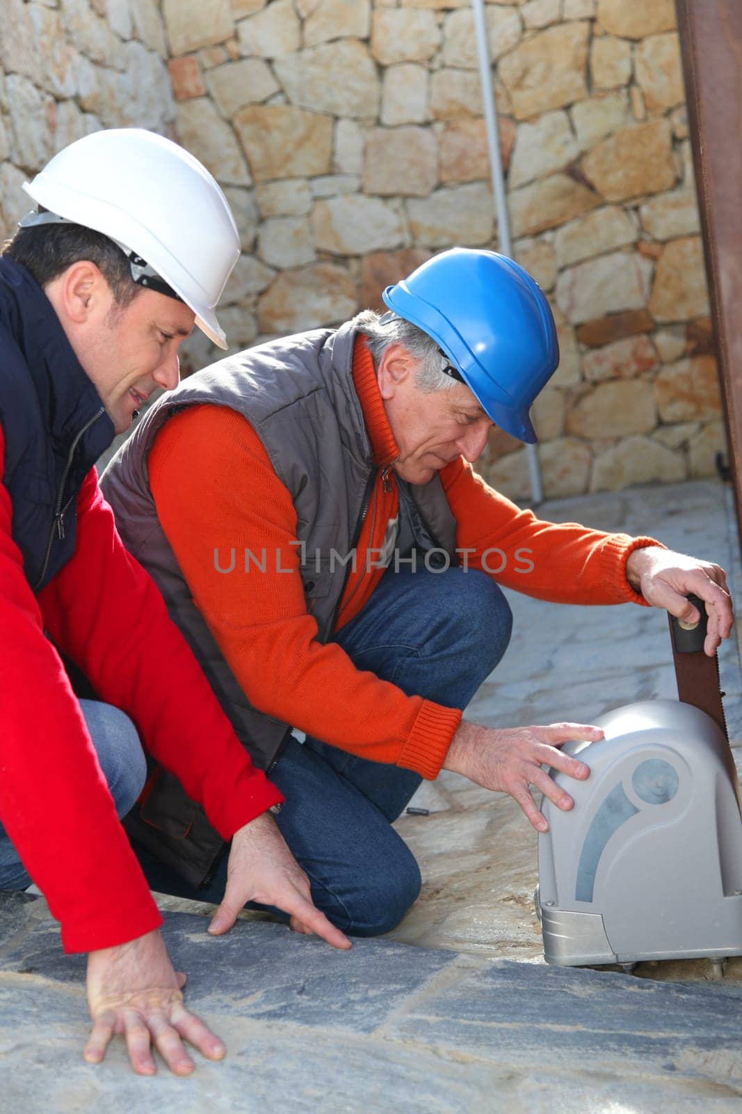 Workers with security helmet installing gate system
