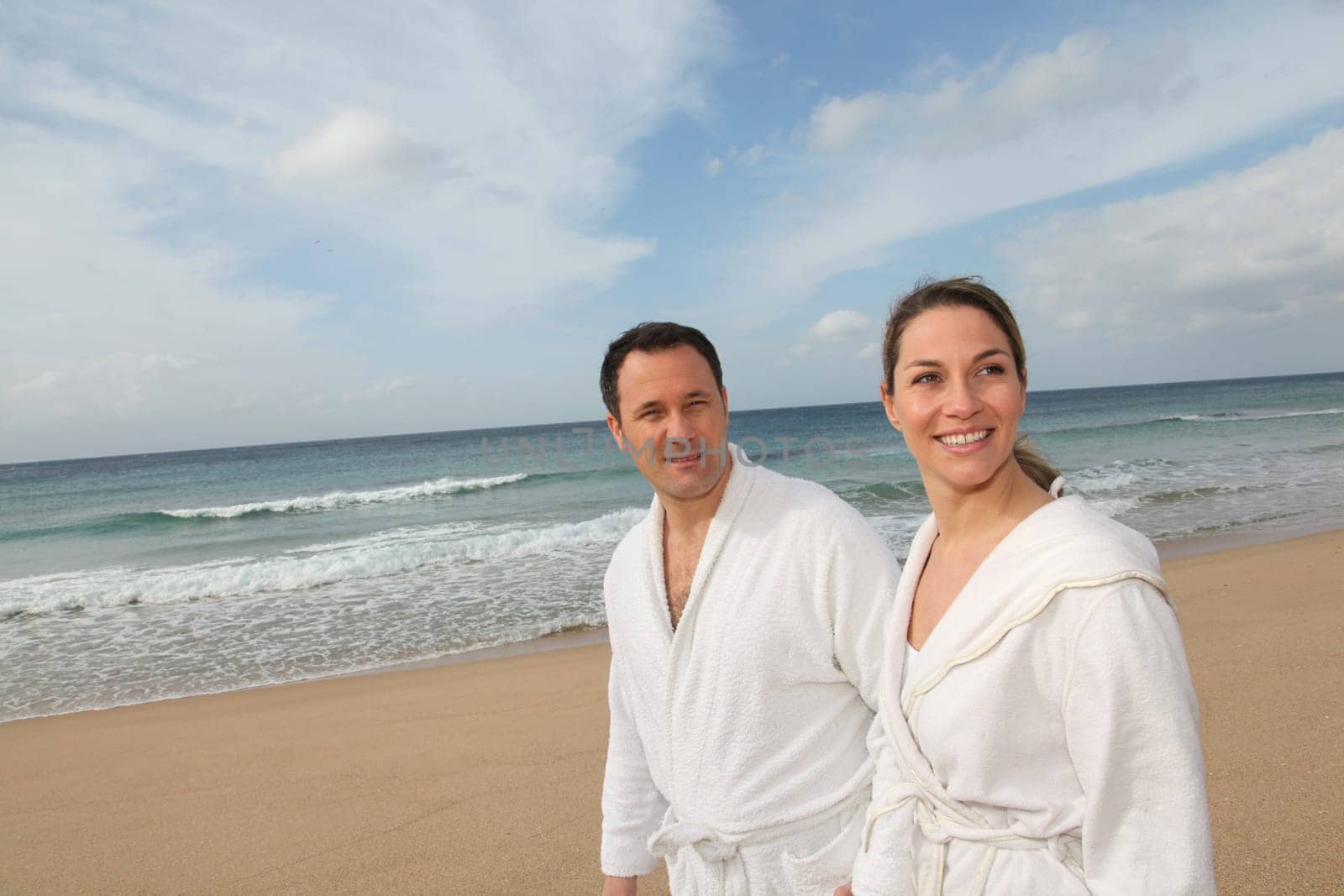 Couple relaxing in bathrobe at the beach