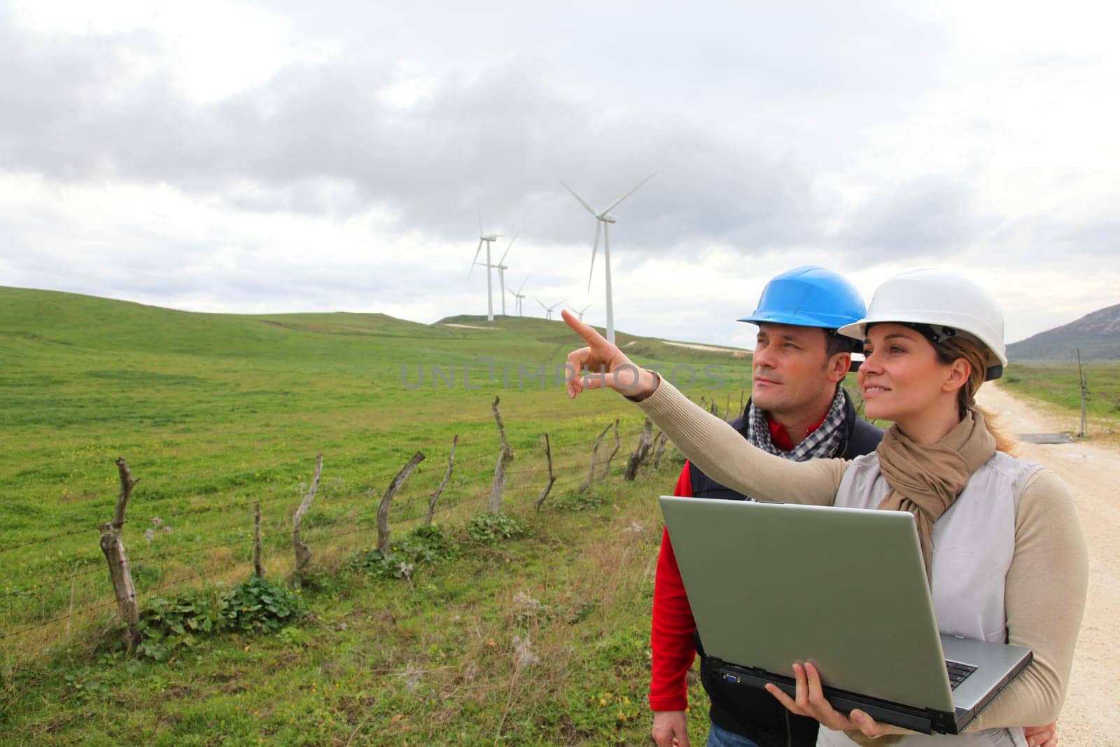 Engineers working by wind turbines field