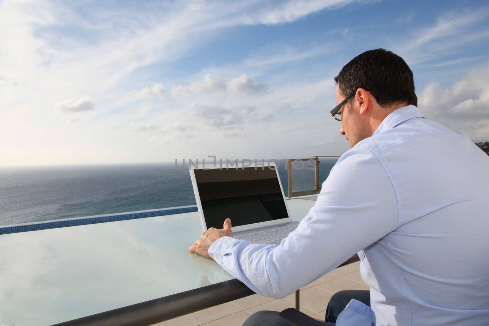 Man working in front of the sea during vacation time