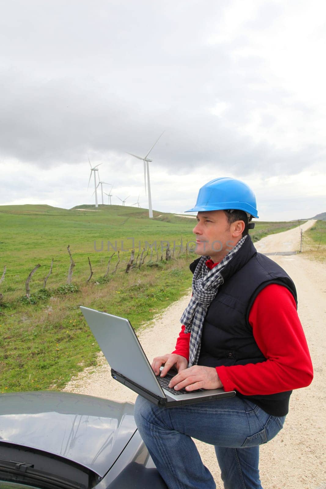 Engineer working on laptop computer in wind turbines field