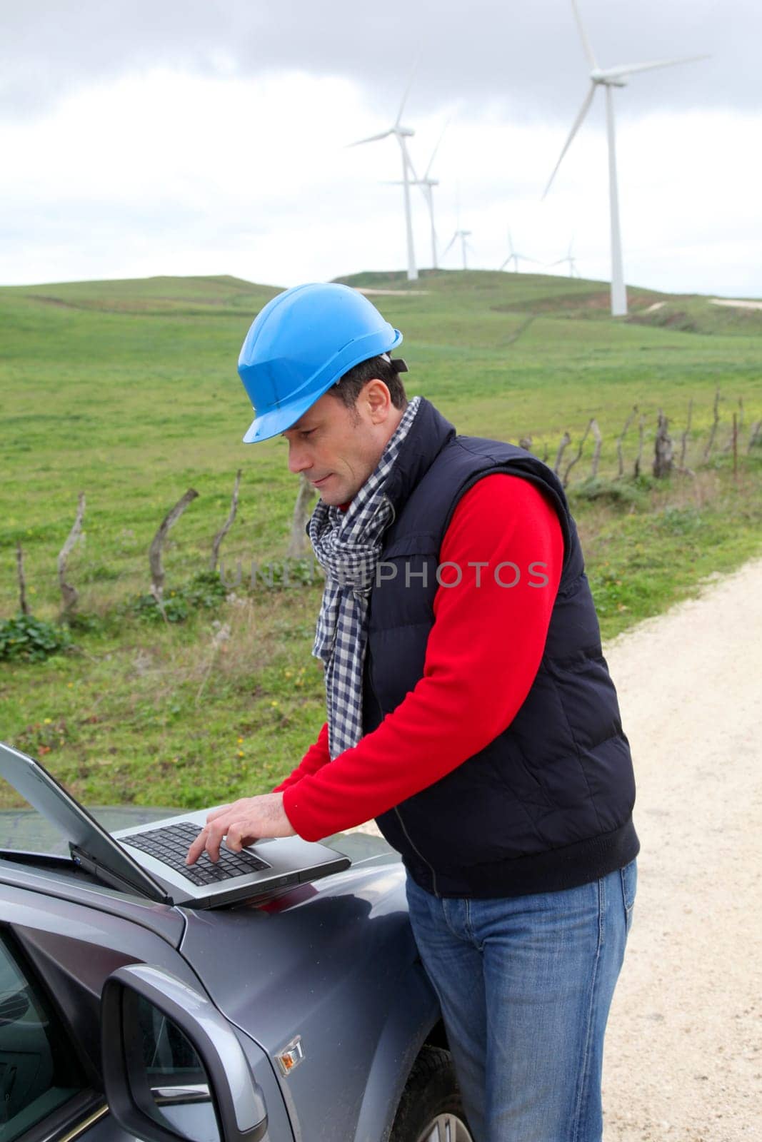 Engineer working on laptop computer in wind turbines field