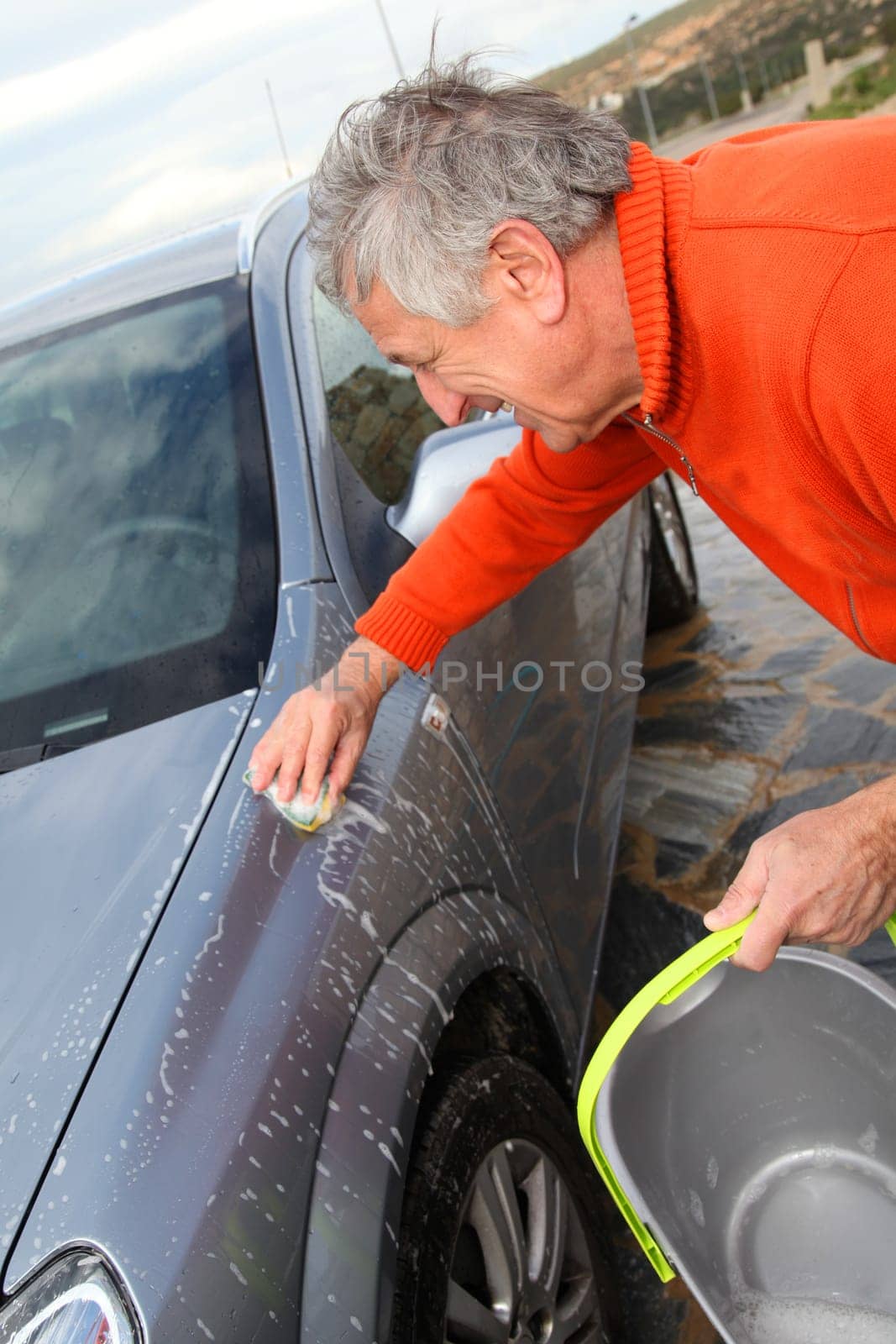 Senior man washing his car