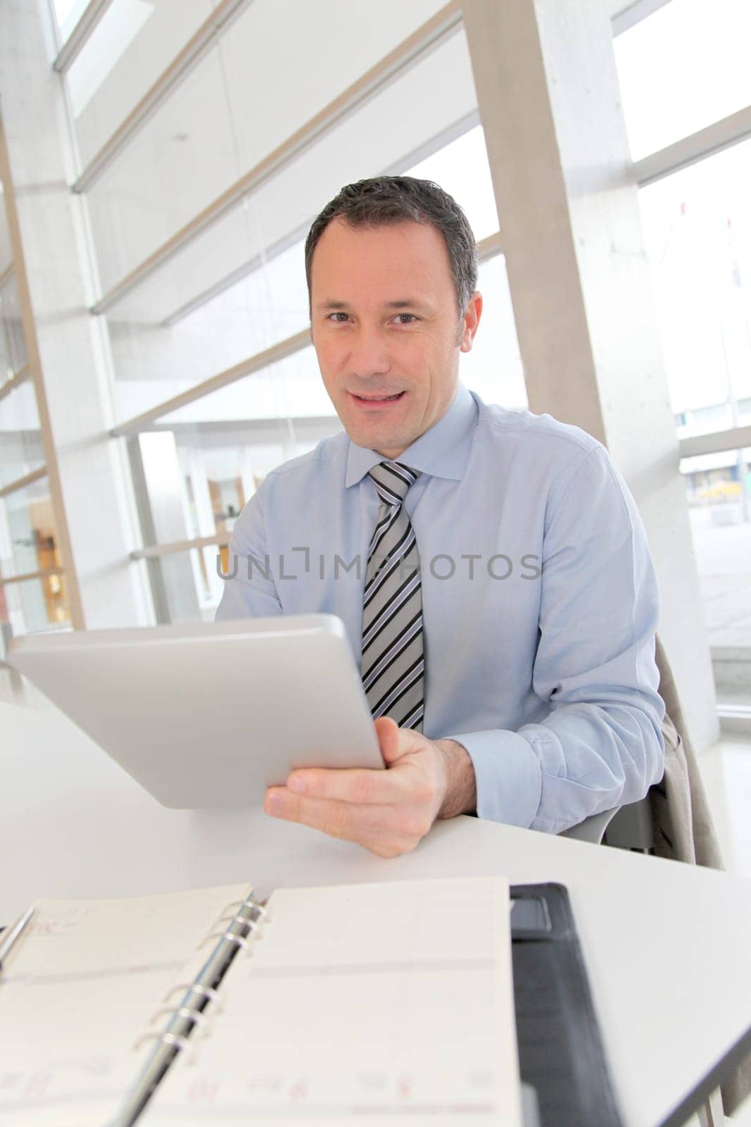 Businessman sitting in the office with electronic tab