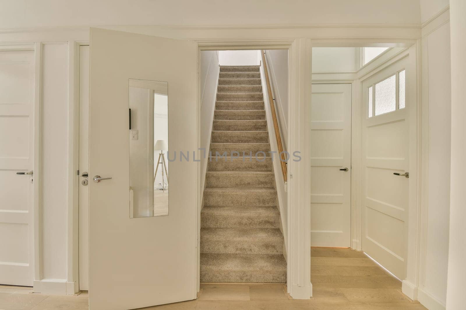 an empty room with stairs leading up to the second floor and two doors on either side facing each other rooms