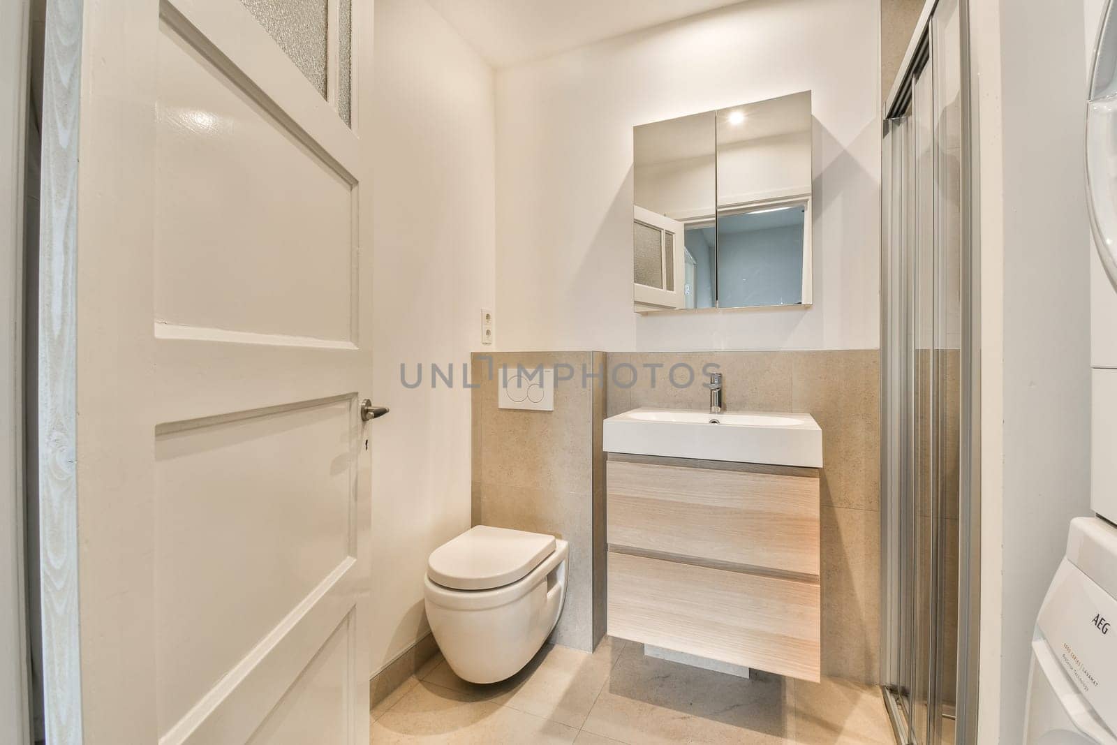 a bathroom with a toilet, sink and mirror on the wall next to the washer in the shower stall