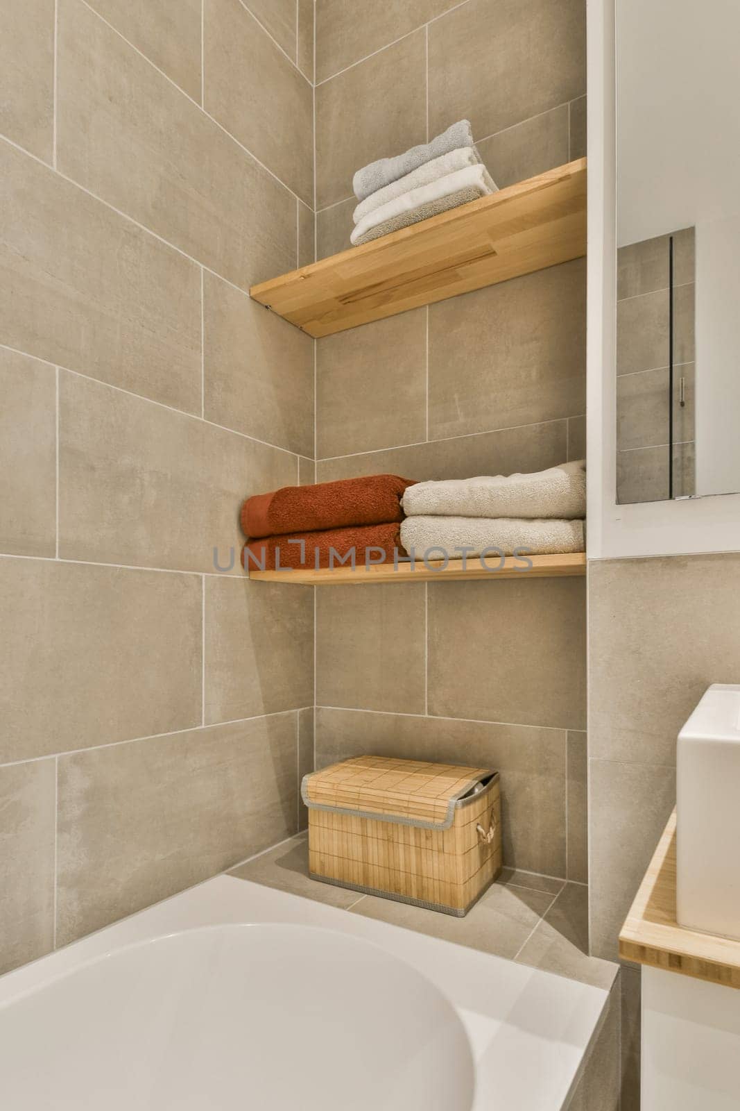 a bathroom with a tub and a shelf with towels by casamedia