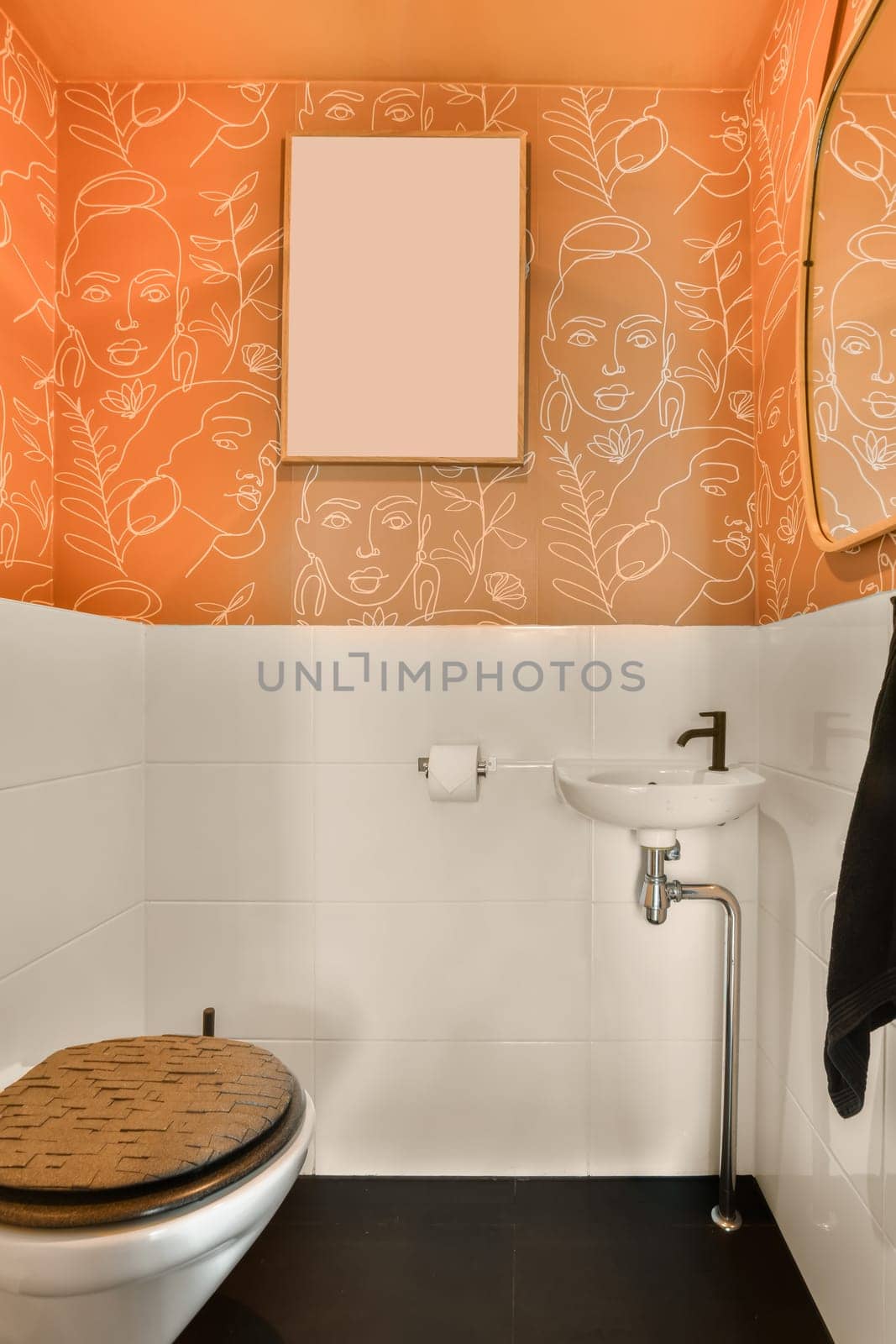a bathroom with an orange wall and white tiles on the walls, along with a toilet in front of a mirror
