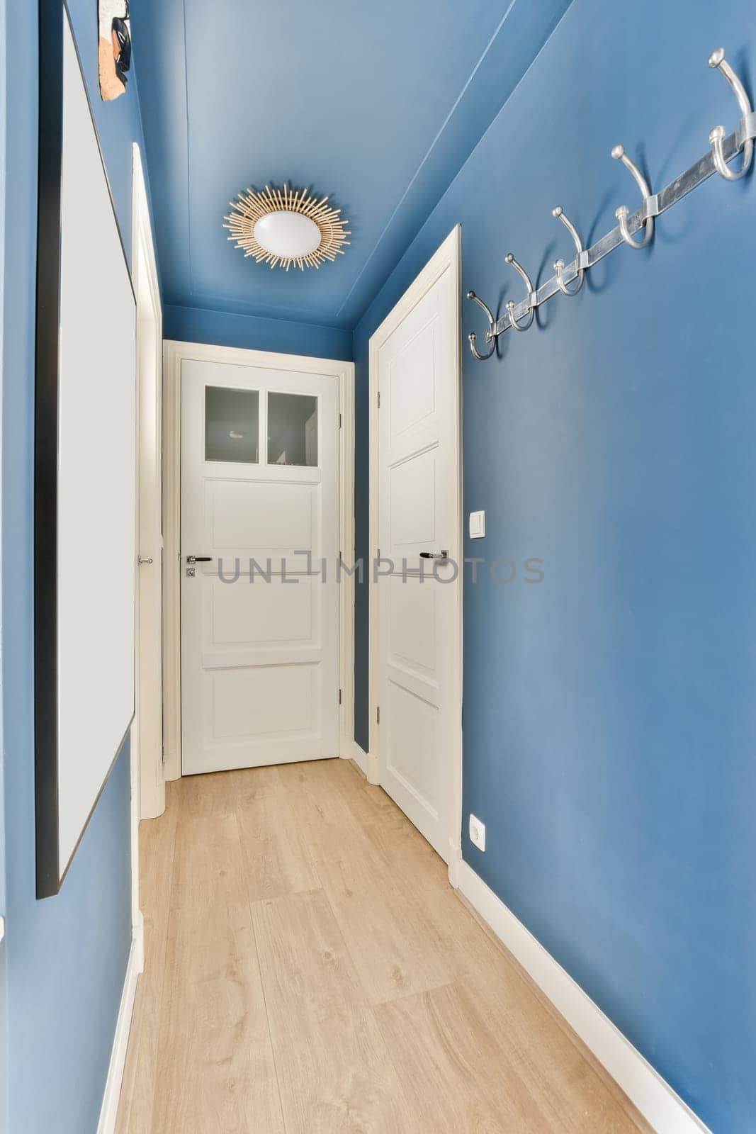 a hallway with blue walls and a white door by casamedia