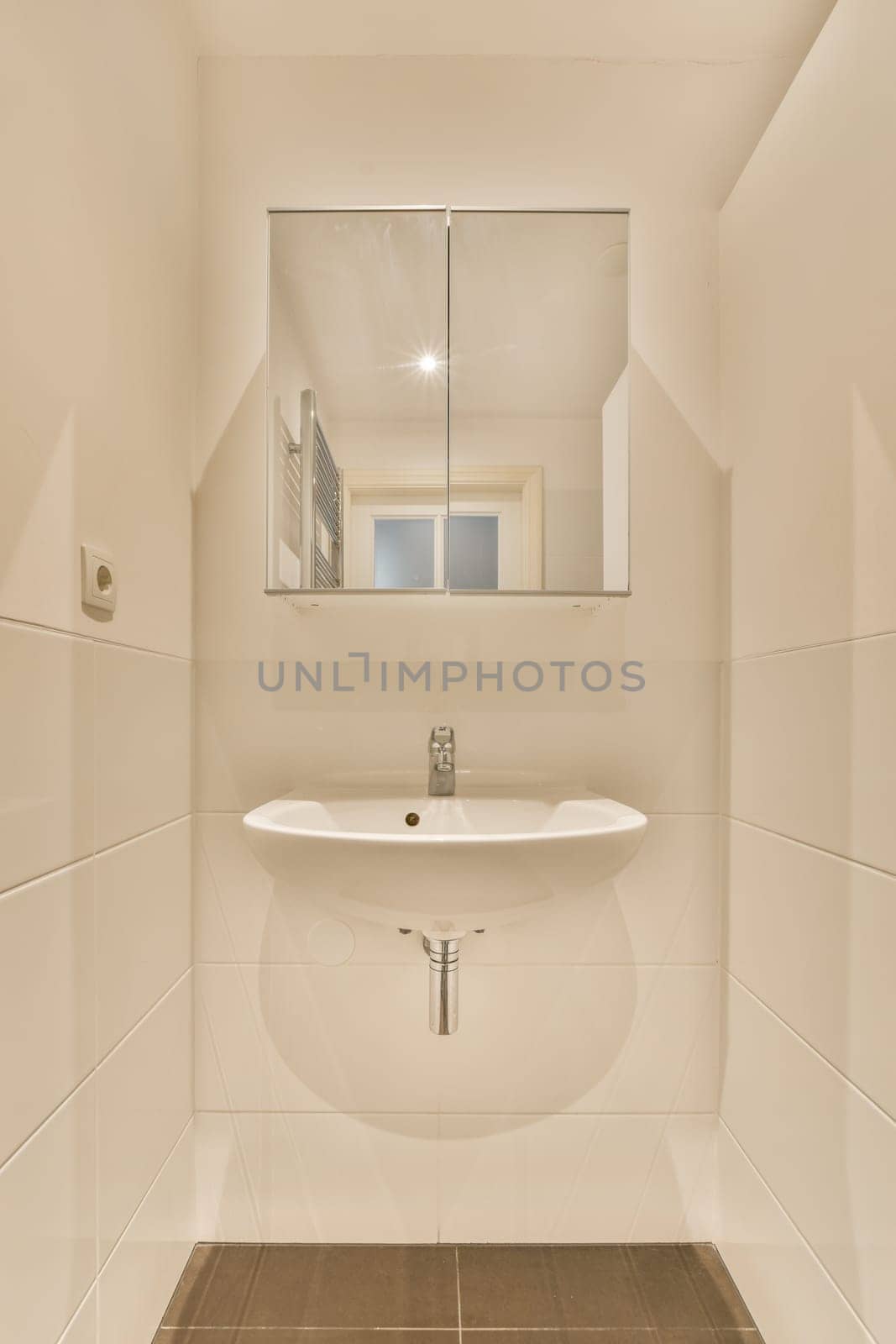 a bathroom with a sink and mirror on the wall, in front of it is a tiled floor that looks very clean