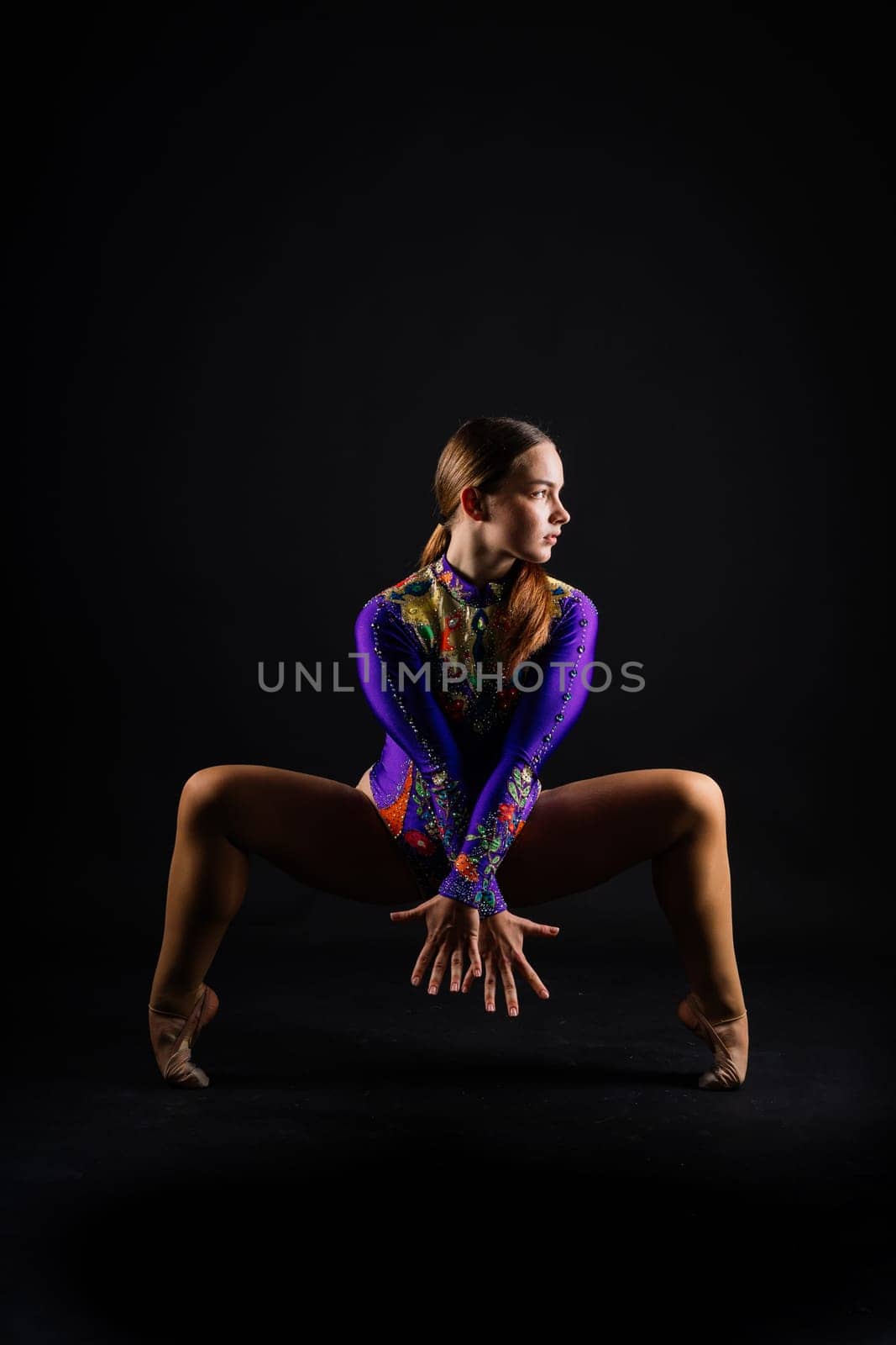 Sportive exercises, standing and stretching the hands. Beautiful muscular woman is indoors studio. by Zelenin