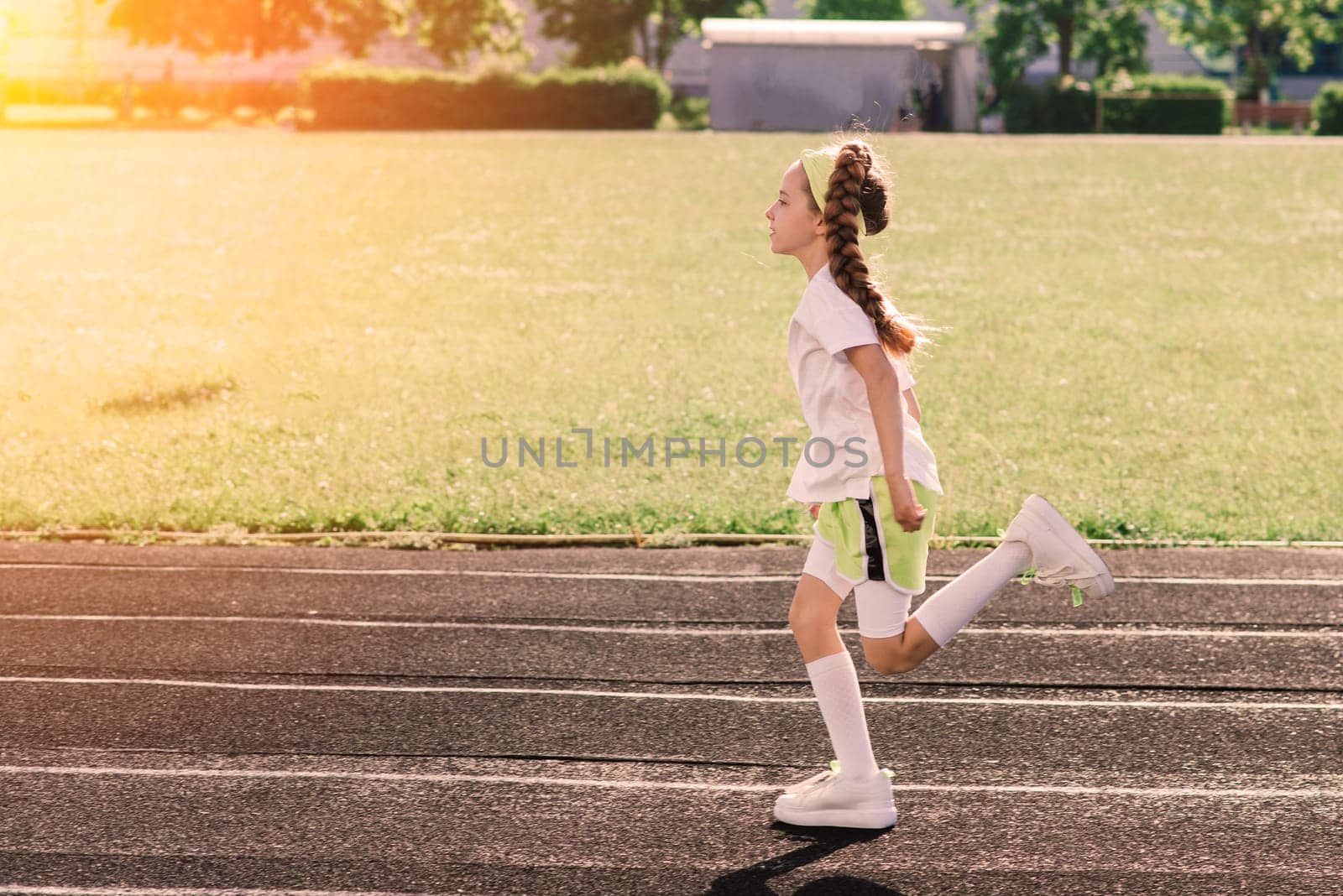 Girl jogging on a sunny summer evening, laying on treadmill, stadium, physical training, back to school, tired.