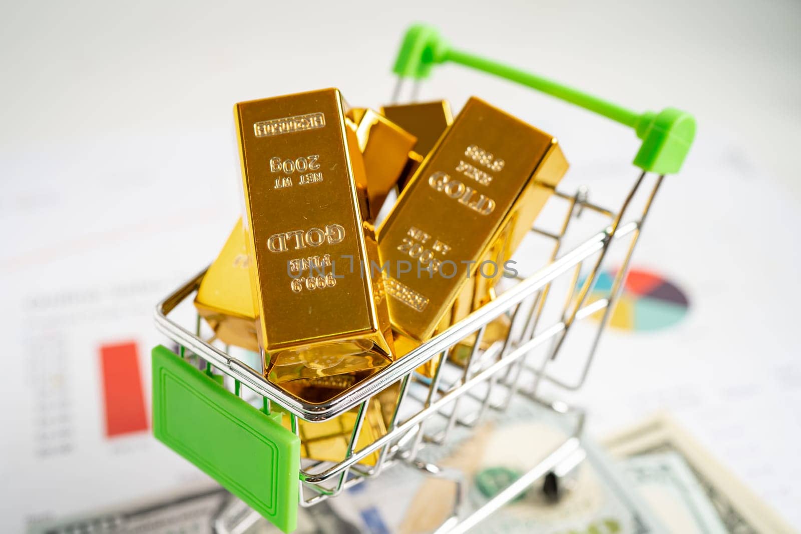 Gold bar in shopping cart on US dollar banknotes money and graph, economy finance exchange trade investment concept. by pamai