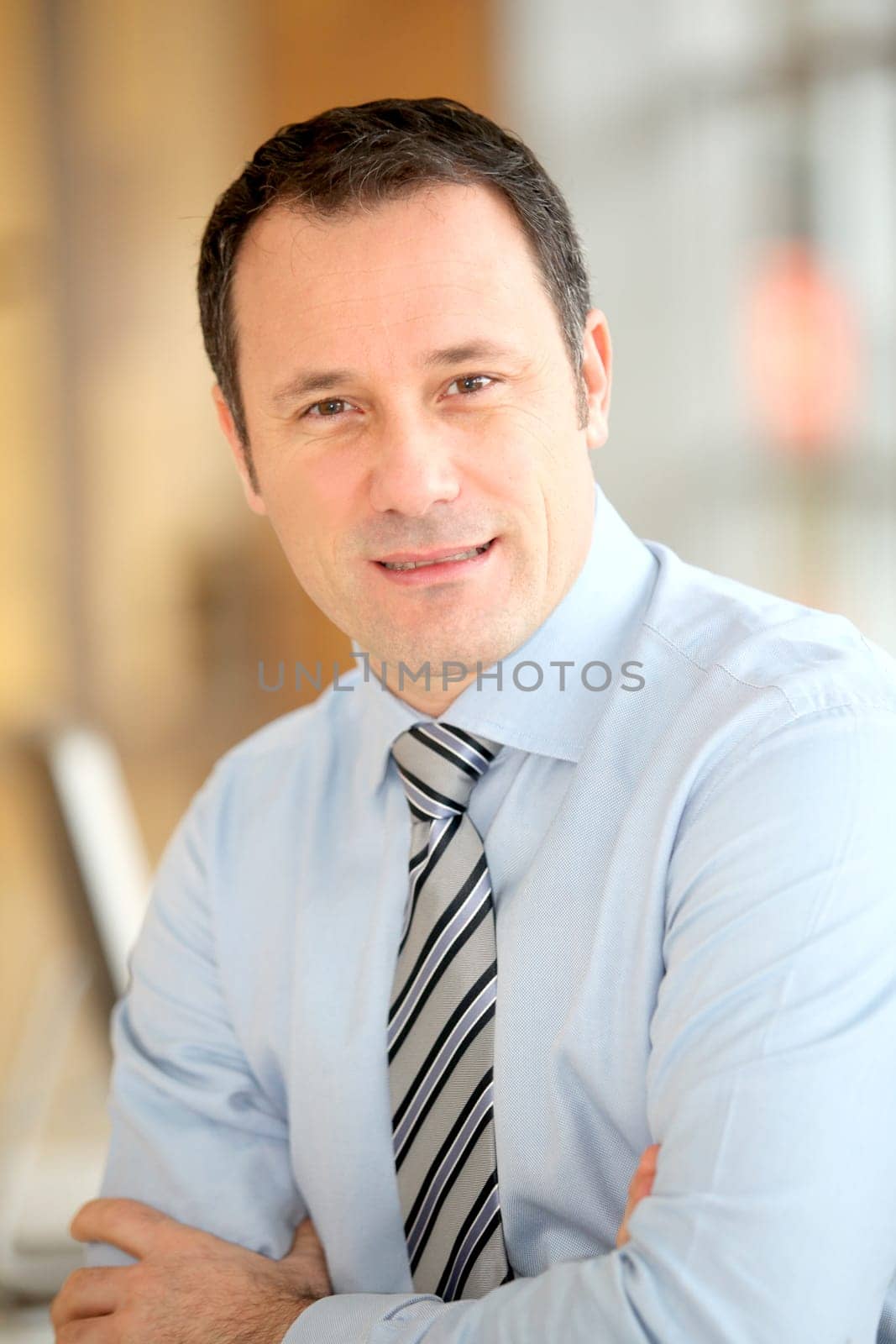 Portrait of smiling businessman with arms crossed