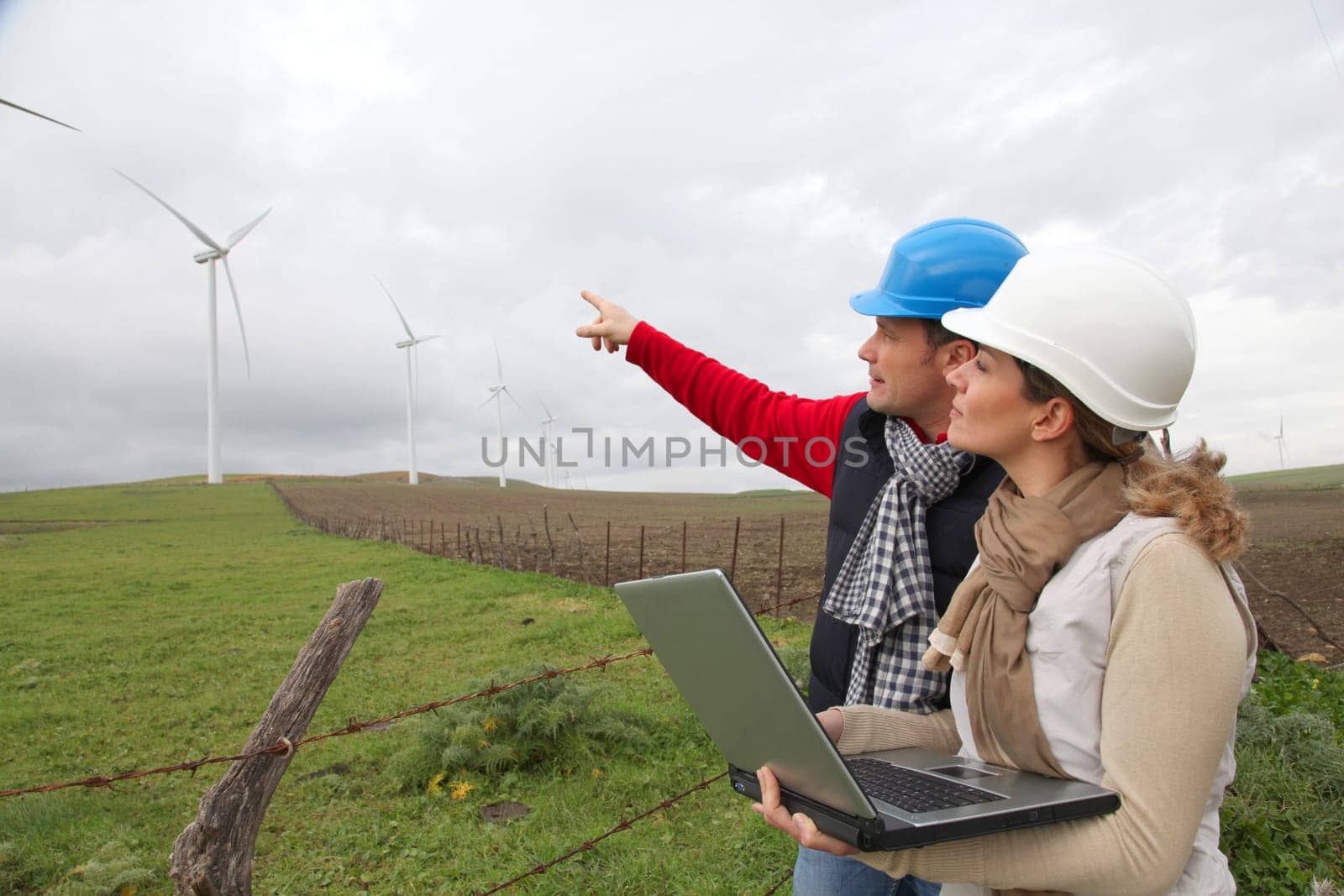 Engineers working by wind turbines field