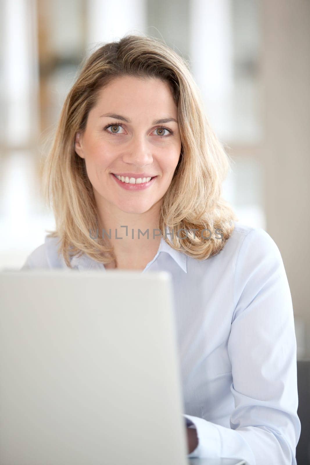 Smiling office worker in front of laptop computer