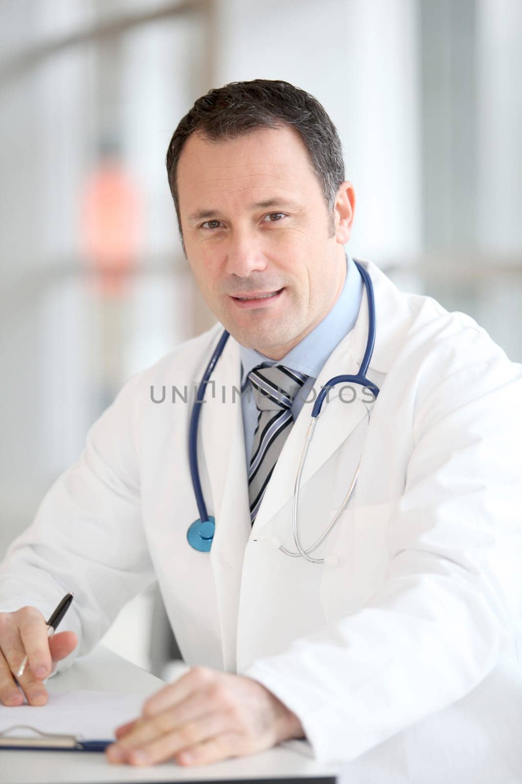 Closeup of handsome doctor sitting at his desk