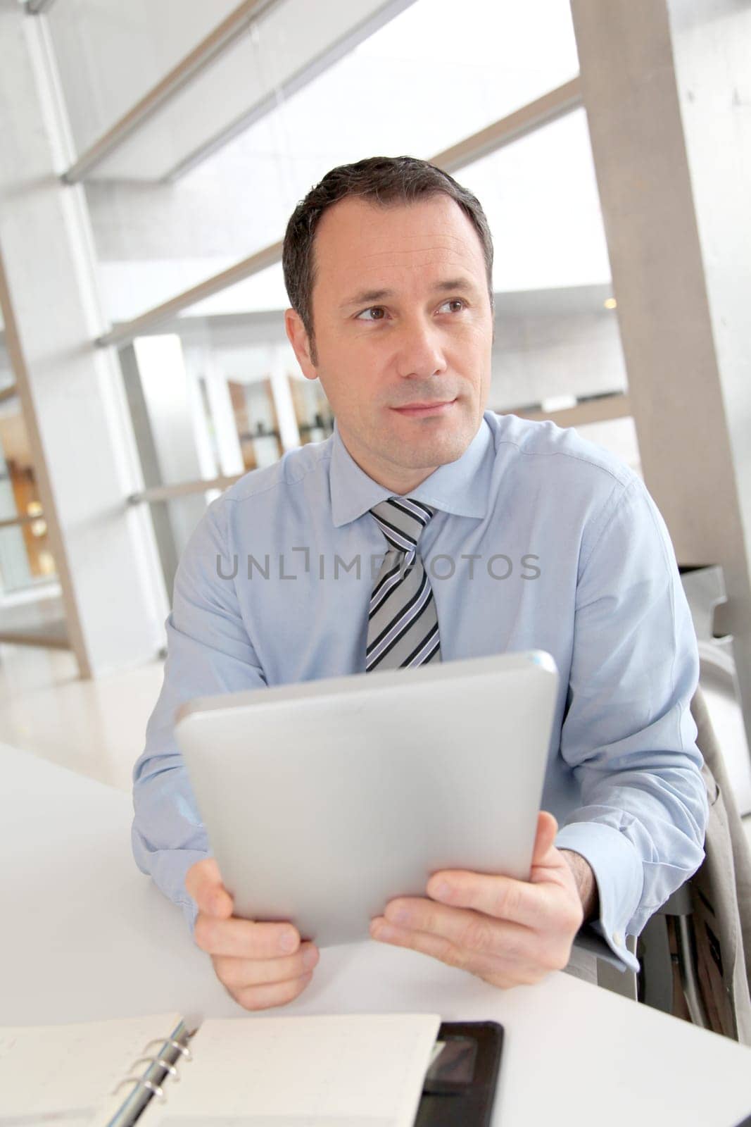 Businessman sitting in the office with electronic tab