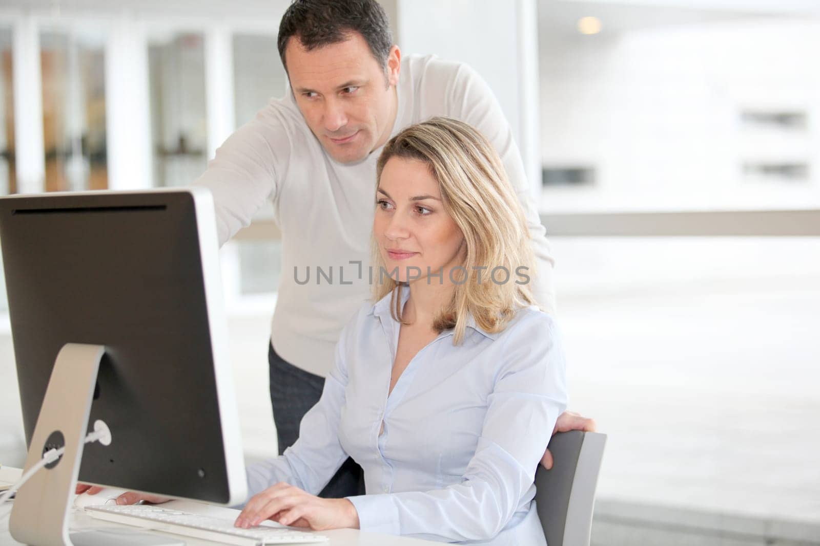 Office workers in front of desktop computer