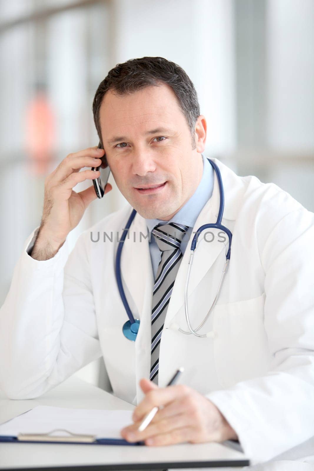 Portrait of handsome doctor talking on the phone