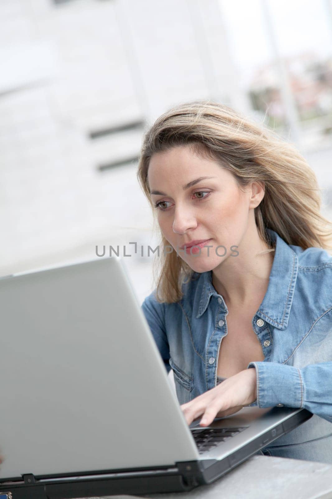 Woman using laptop computer in the street