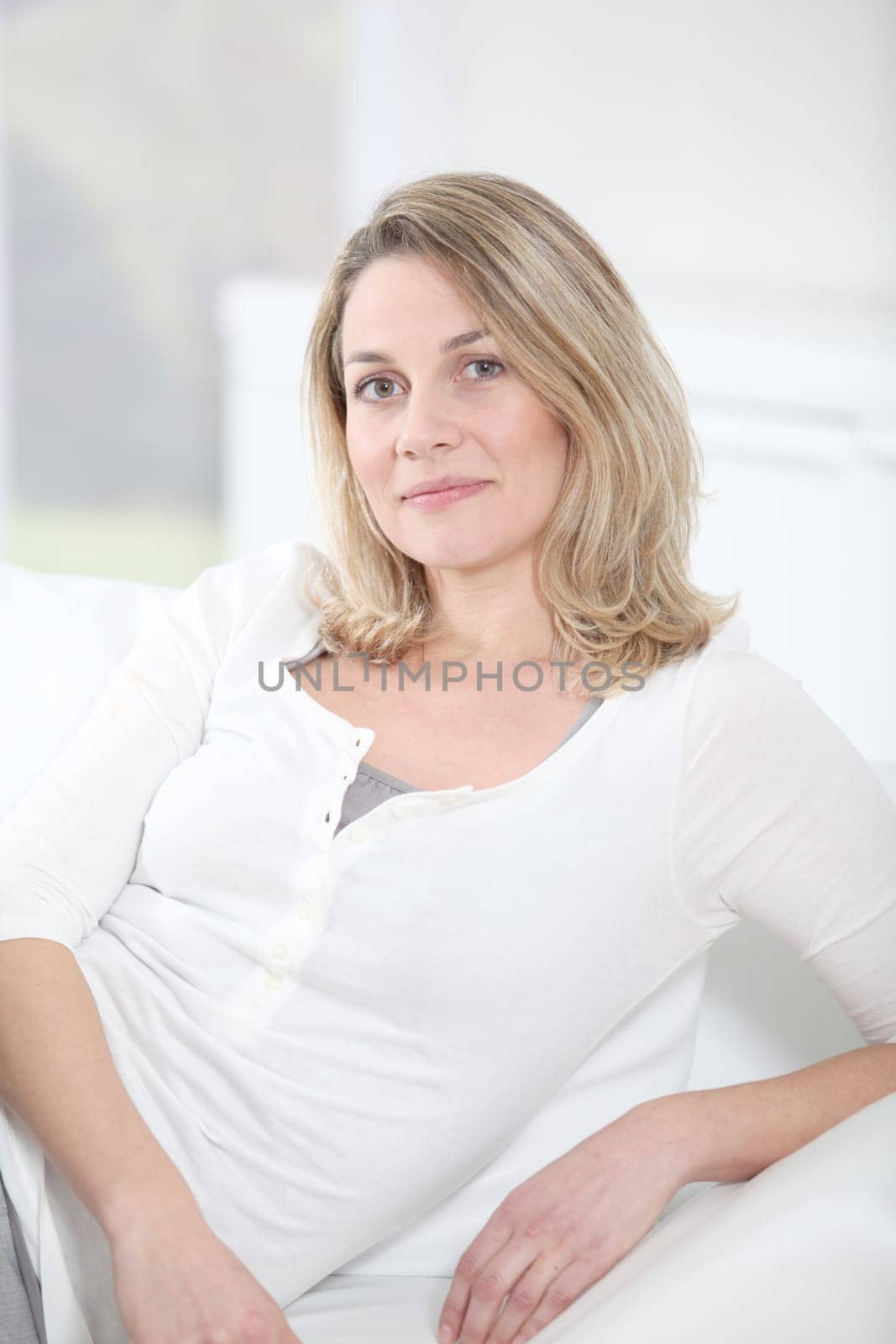 Portrait of beautiful blond woman sitting on sofa