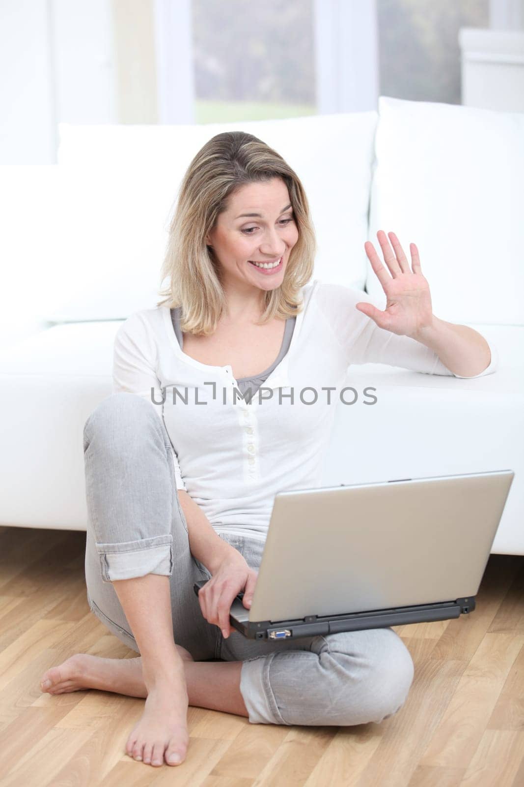 Blond woman waving at webcamera