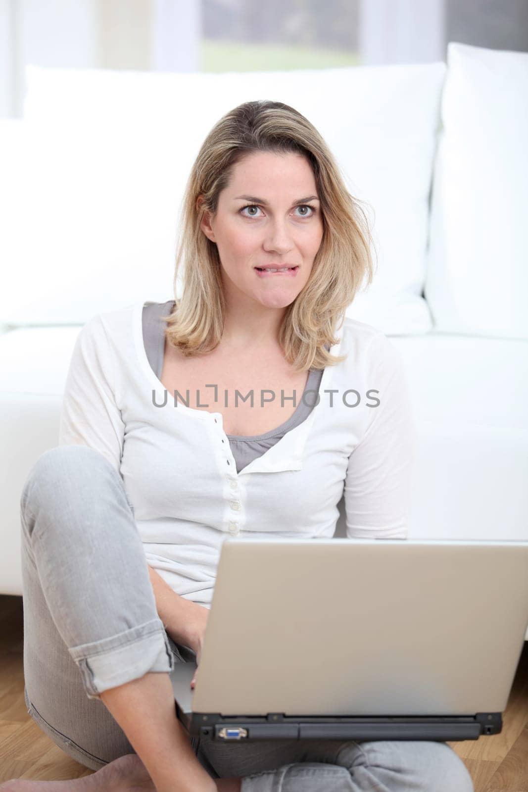 Blond woman using laptop computer at home