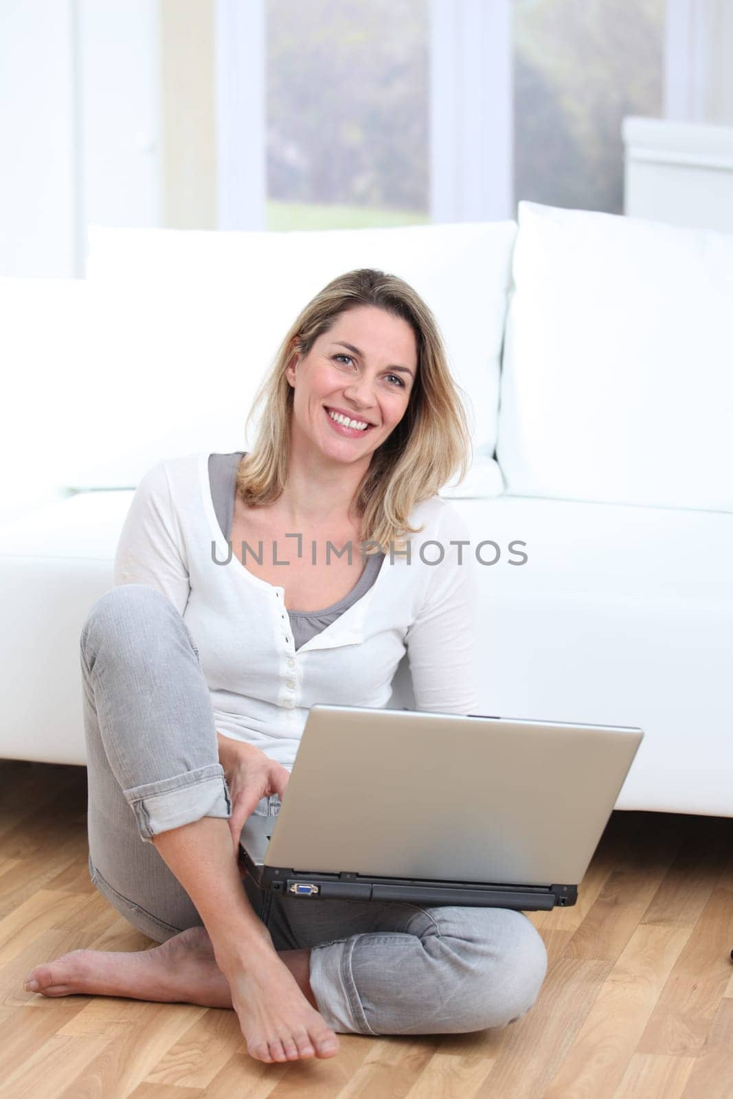 Blond woman using laptop computer at home