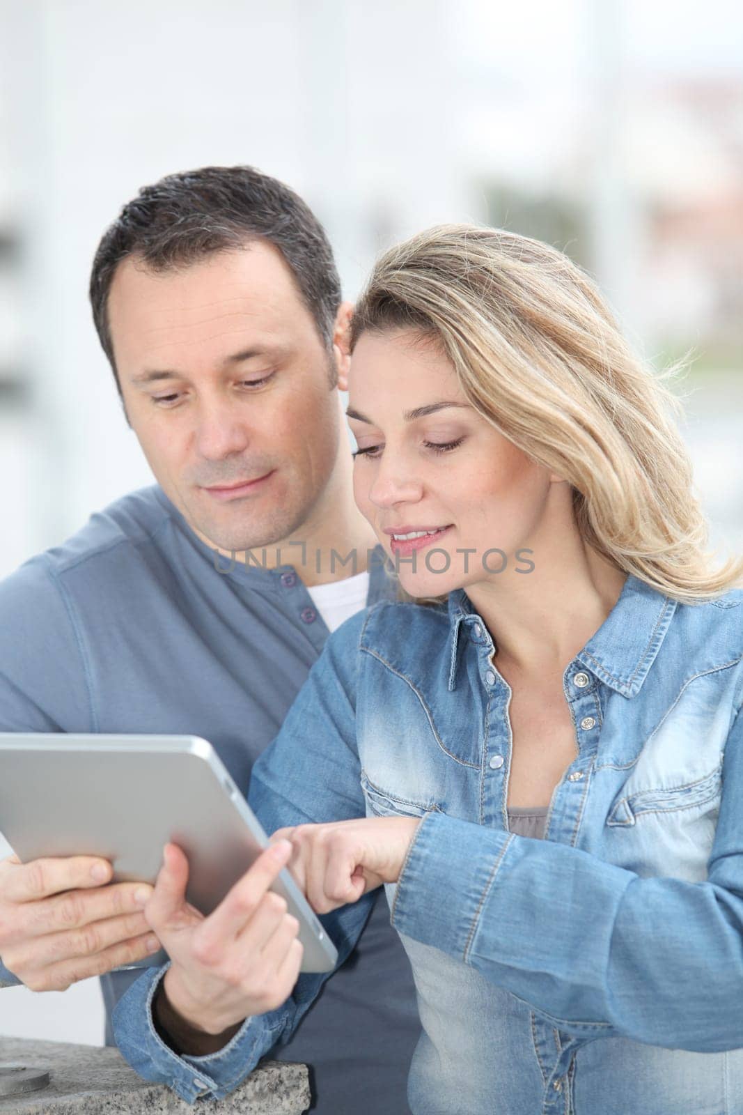 Couple using electronic tab in the street