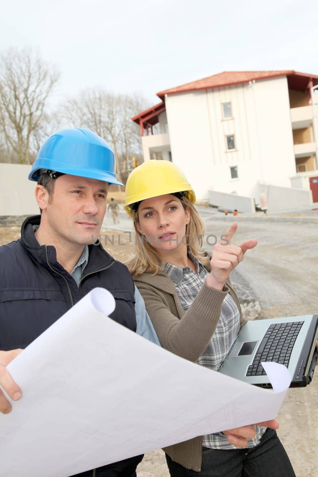 Architect and engineer looking at plan on construction site