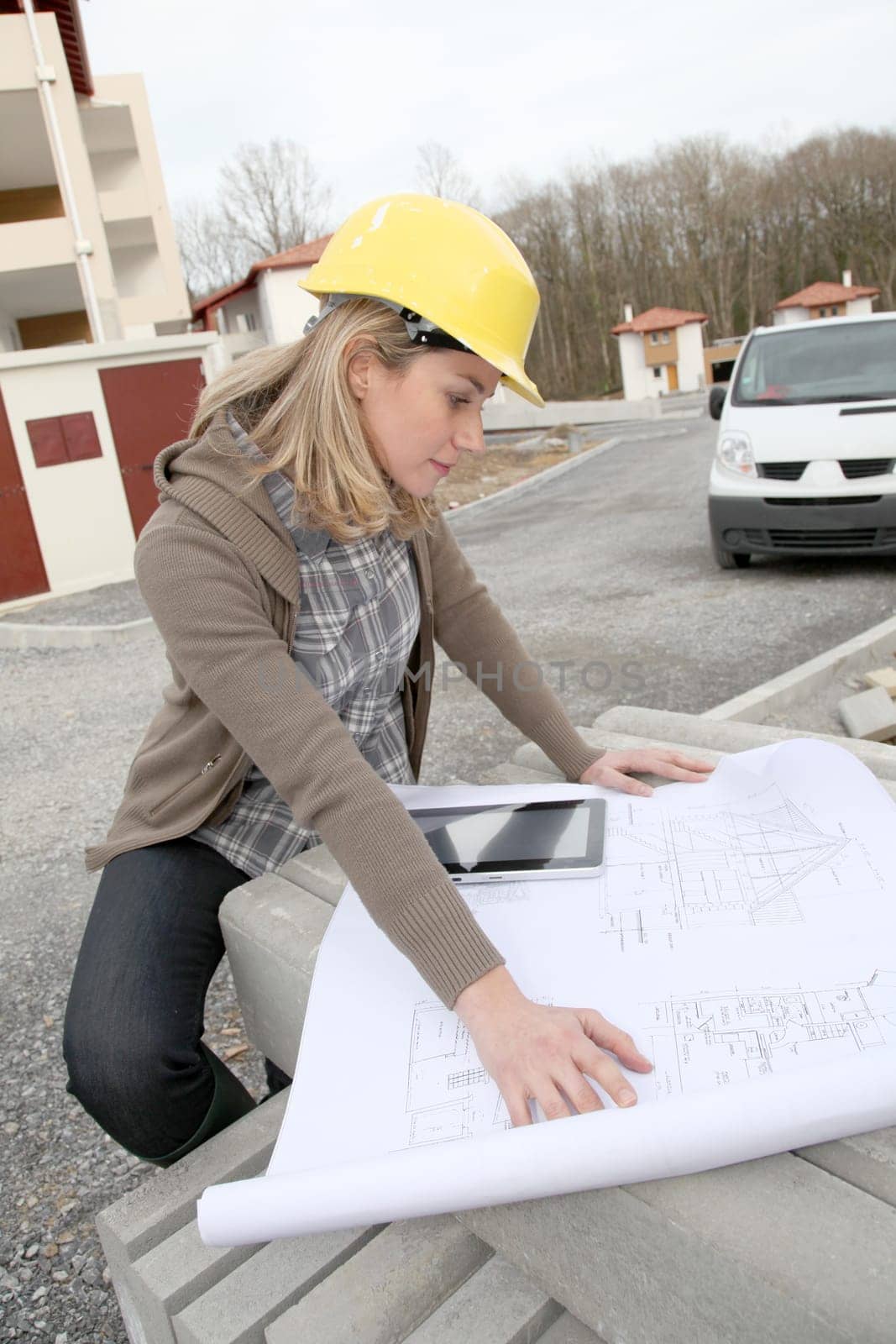 Woman engineer looking at plan on construction site