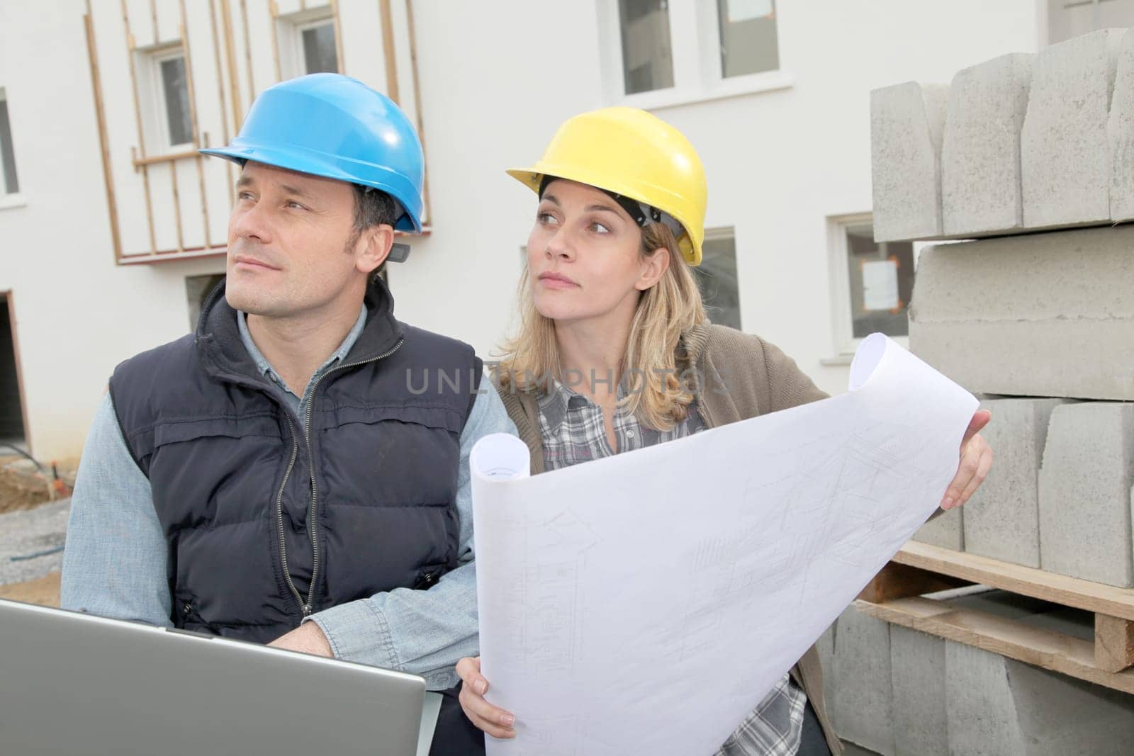 Architect and engineer looking at plan on construction site