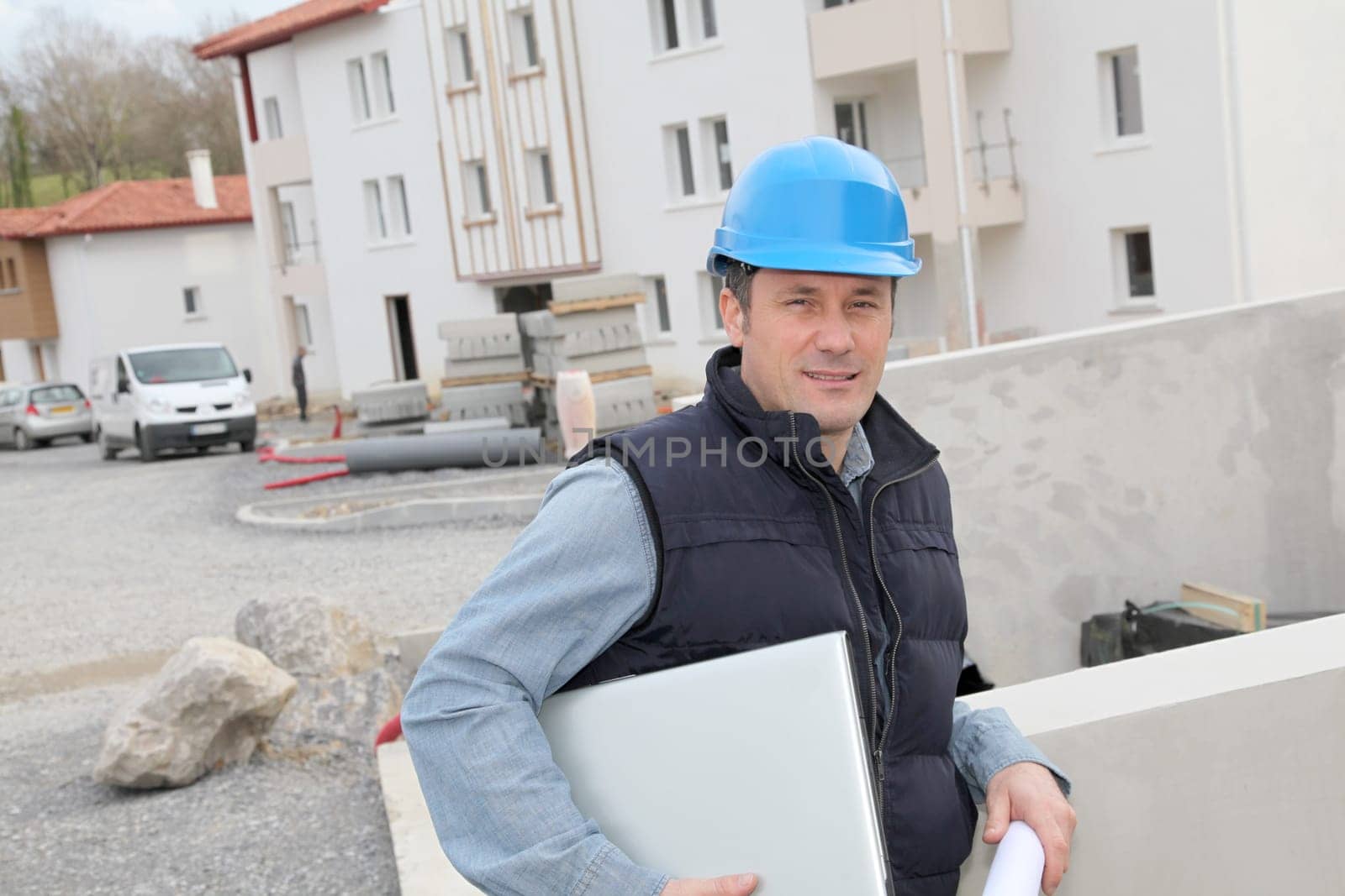Site supervisor with security helmet standing on construction site