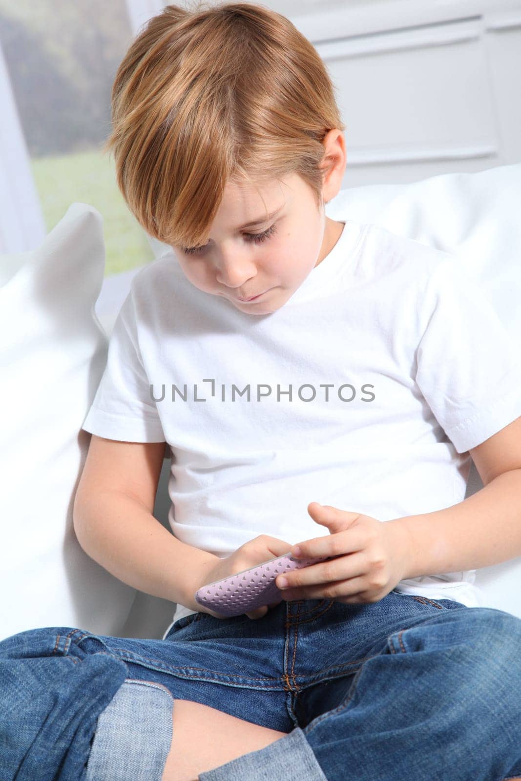 Portrait of little blond kid playing video game