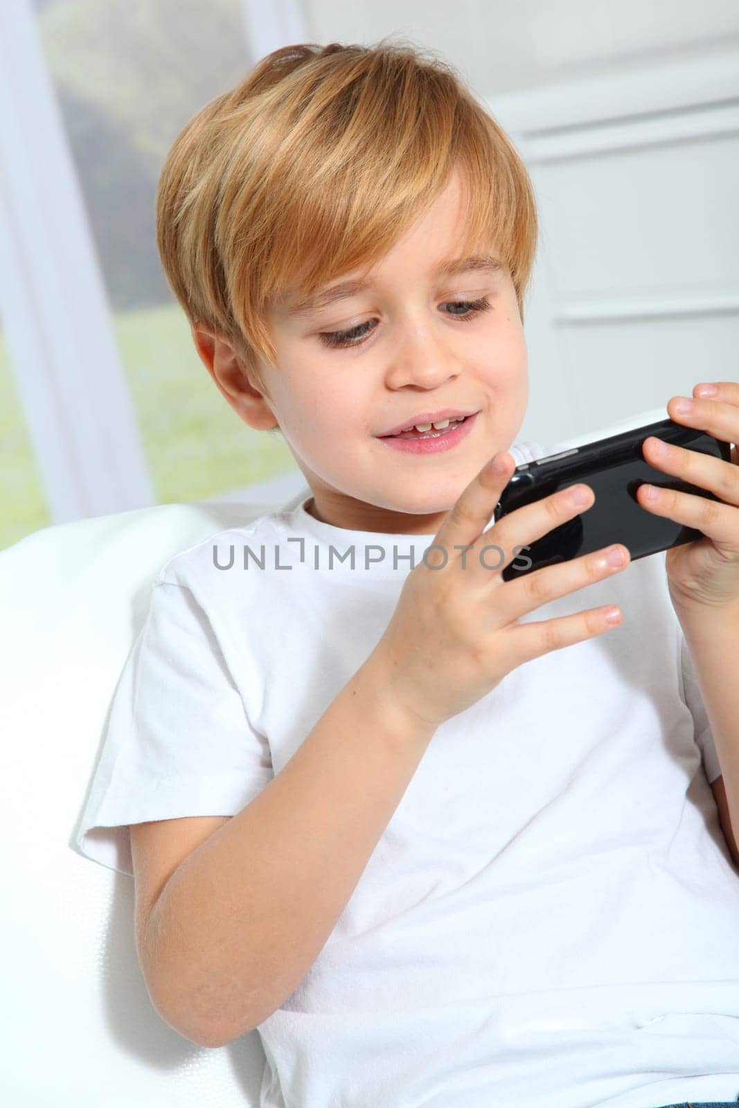 Portrait of little blond kid playing video game