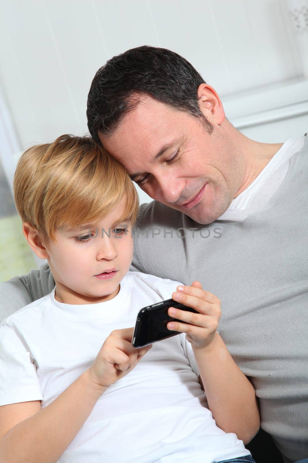 Father and son playing video game at home