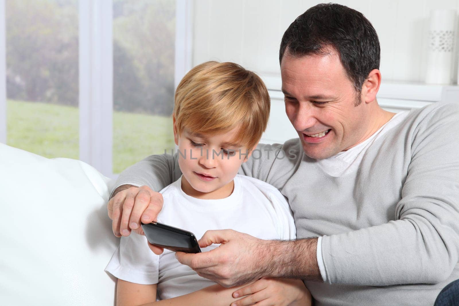 Father and son playing video game at home