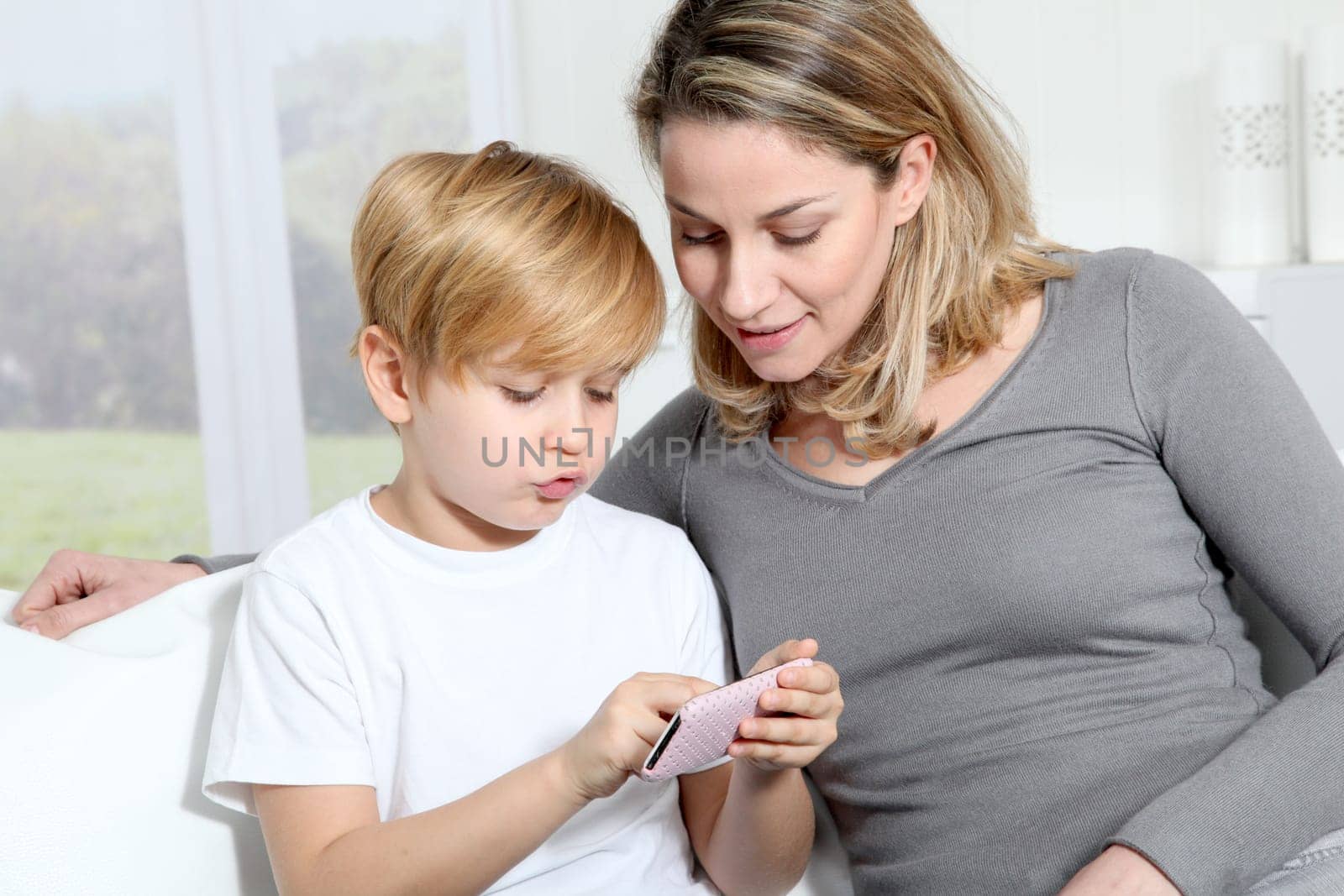 Mother and son playing video game on telephone