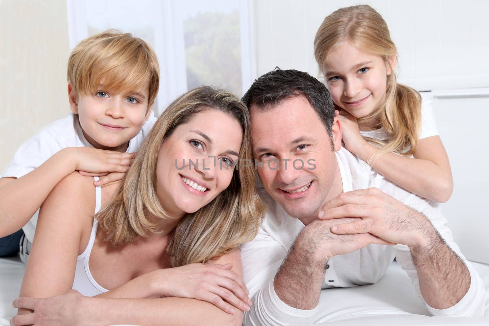 Happy family laying on bed