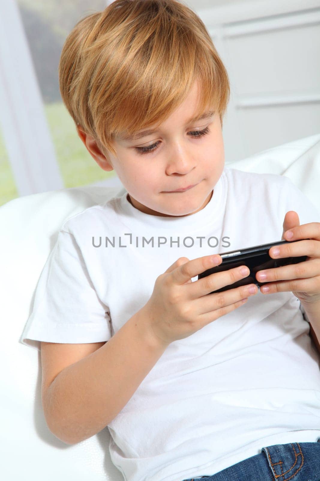 Portrait of little blond kid playing video game