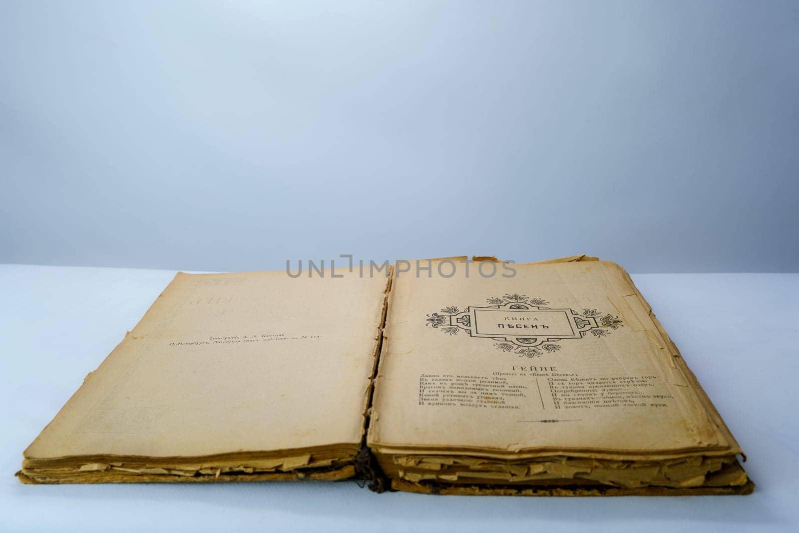 Open old book with fragile, yellowed pages and a vintage black-and-white illustration. Aged historical literature, perfect for themes of knowledge, history, and nostalgia