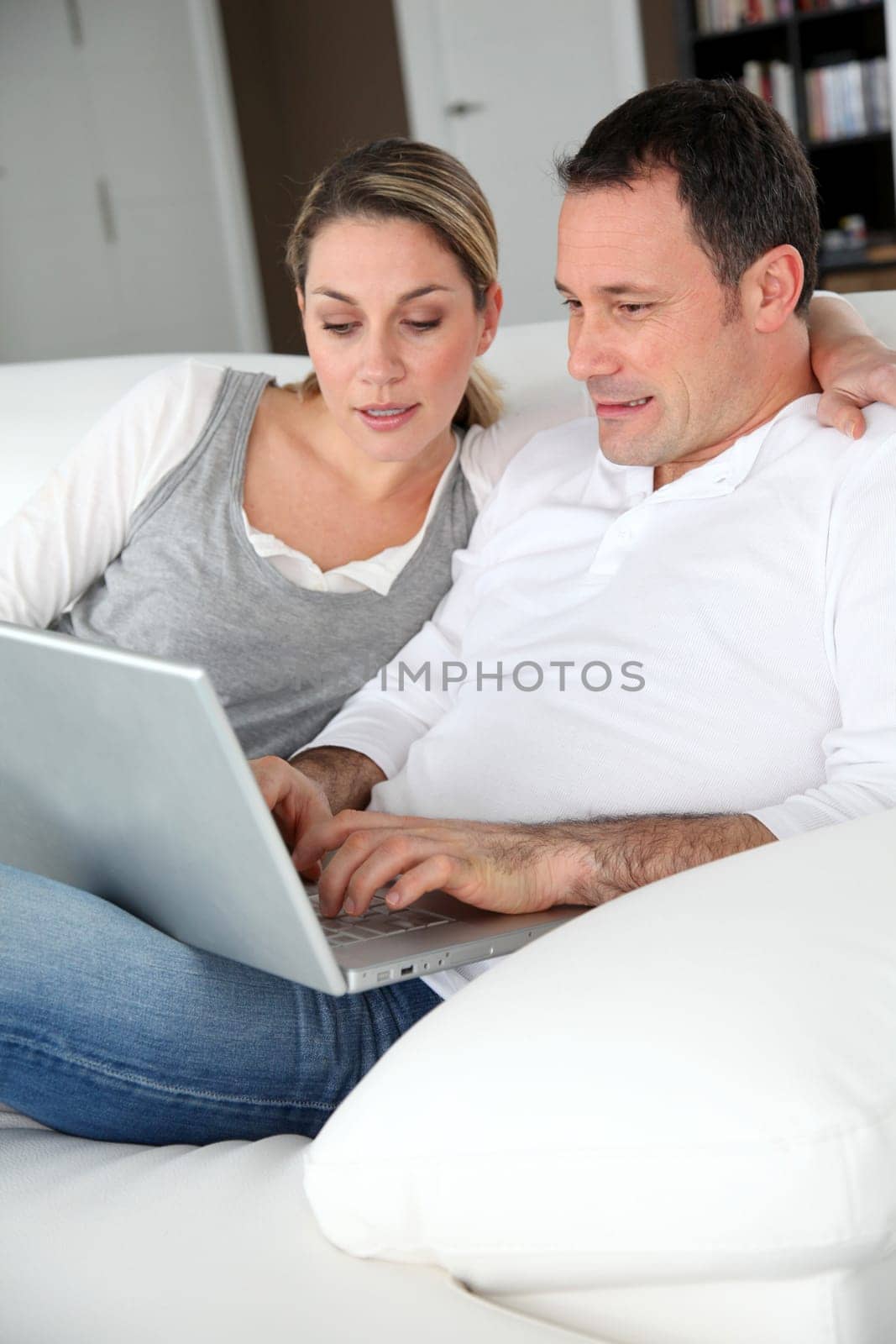Couple relaxing in sofa with laptop computer