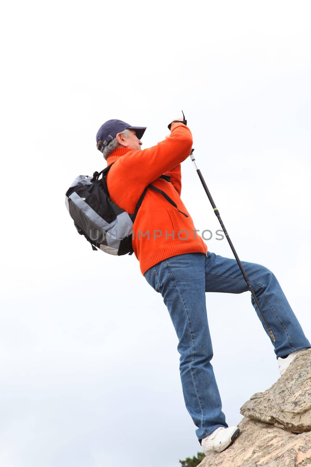 Senior trekker standing on rock