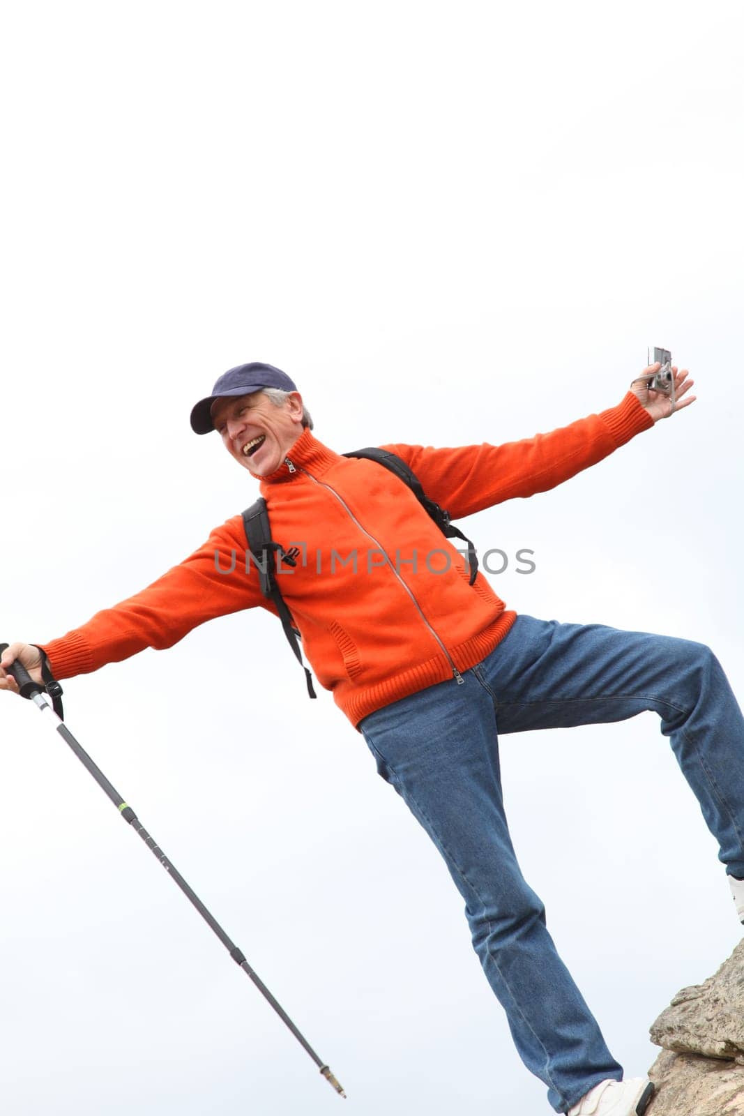Senior trekker standing on rock
