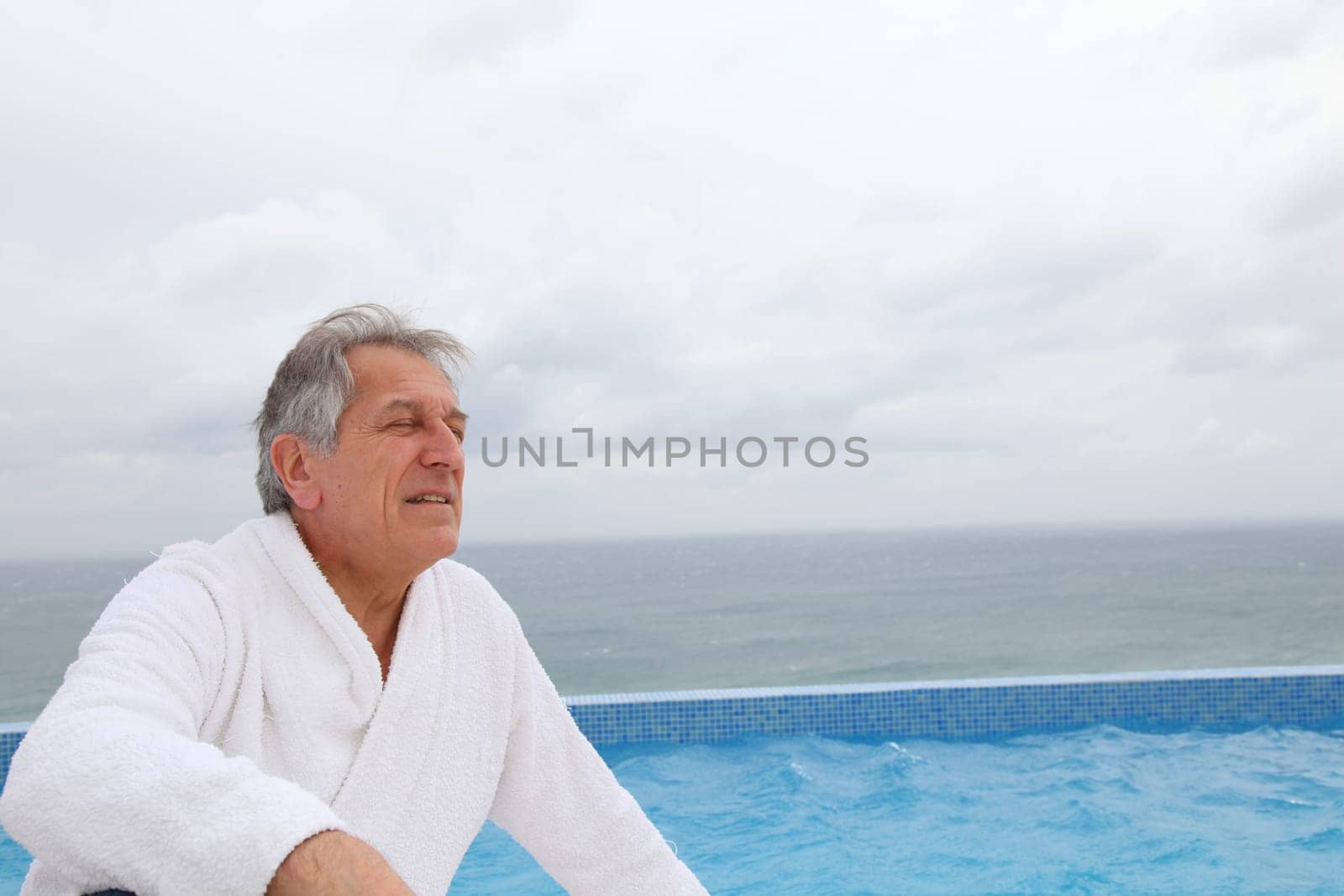 Senior man sitting by pool
