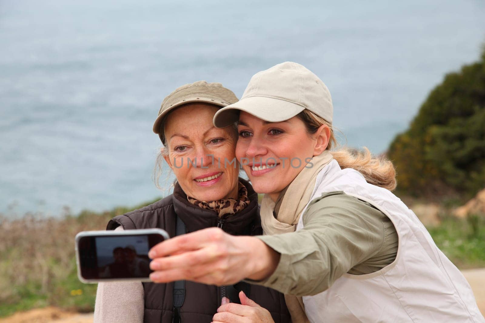 Women taking picture of themselves with telephone