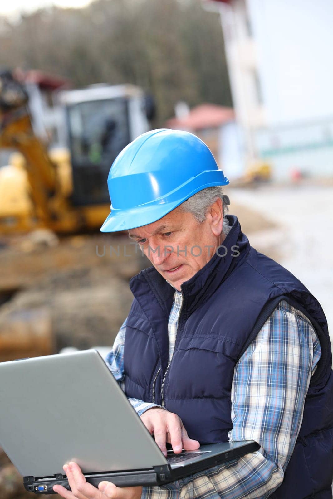 Architect with drawing on construction site