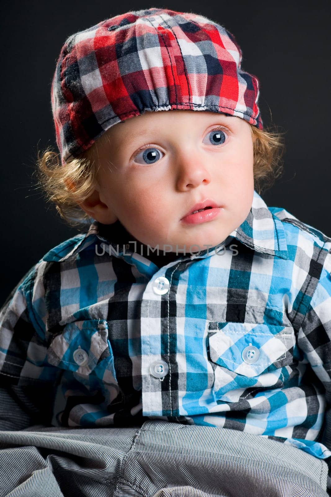 Casual cool young kid with cap against gray background